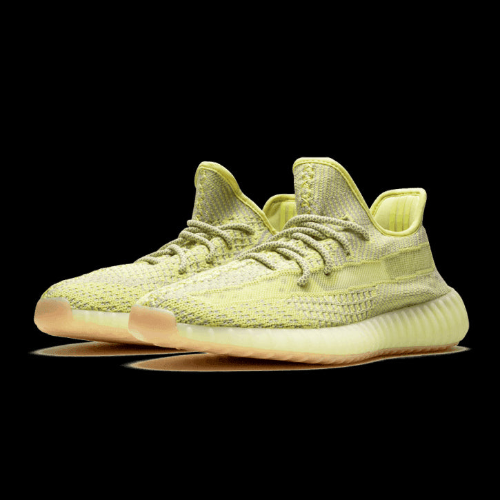 Adidas Yeezy Boost 350 V2 Antlia (Non-Reflective) sneakers in gele kleur, geplaatst op groen interieurvlak.
