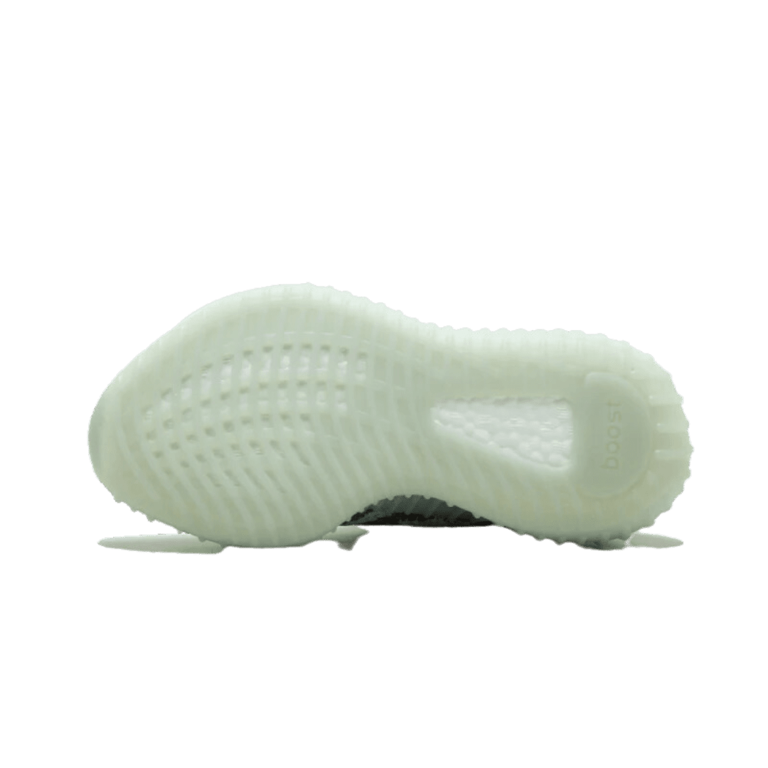 Witte Adidas Yeezy Boost 350 V2 sneakers op groene achtergrond