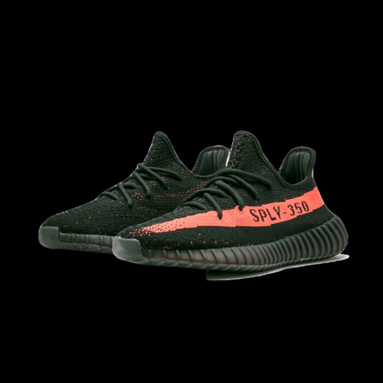 Zwarte Adidas Yeezy Boost 350 V2 Core Black Red sneakers op groene achtergrond