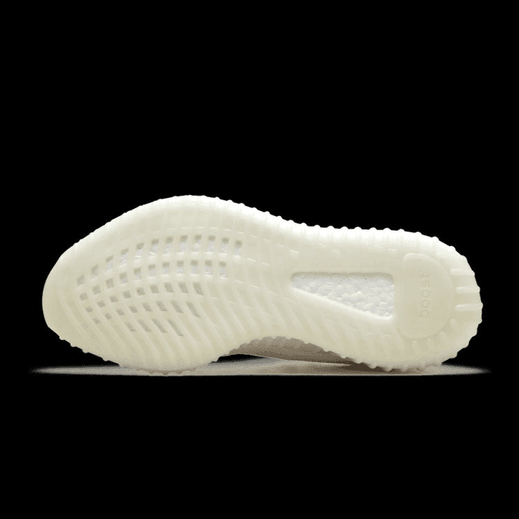 Adidas Yeezy Boost 350 V2 Cream/Triple White sneakers op een effen groene achtergrond