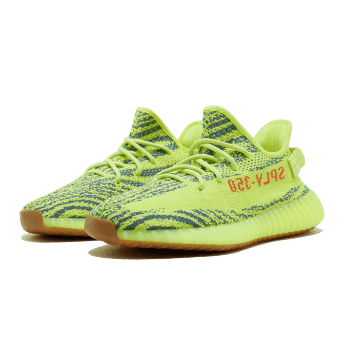 Opvallende neon groene Adidas Yeezy Boost 350 V2 Semi Frozen Yellow sneakers op een groene achtergrond