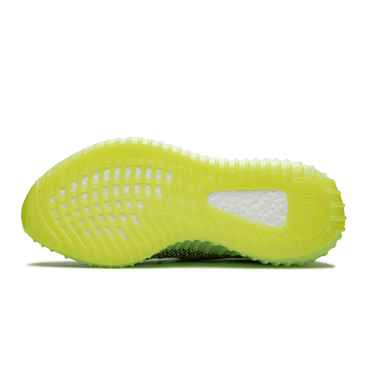 Adidas Yeezy Boost 350 V2 Yeezreel (Non-Reflective) sneaker in felgroen op groene achtergrond. Het schoeisel heeft een opvallend, futuristisch design met geperforeerde details en een dikke, comfortabele zool.