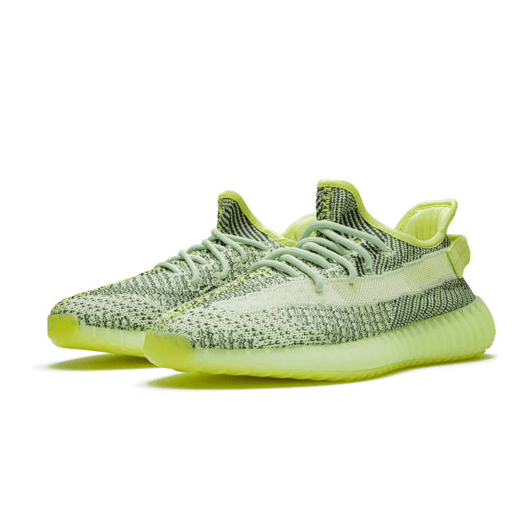 Adidas Yeezy Boost 350 V2 Yeezreel (Non-Reflective) sneakers in een opvallend neongroen getint op een groene achtergrond geplaatst. Deze sportieve en innovatieve schoenen zijn ontworpen voor een stijlvolle en comfortabele look en feel.