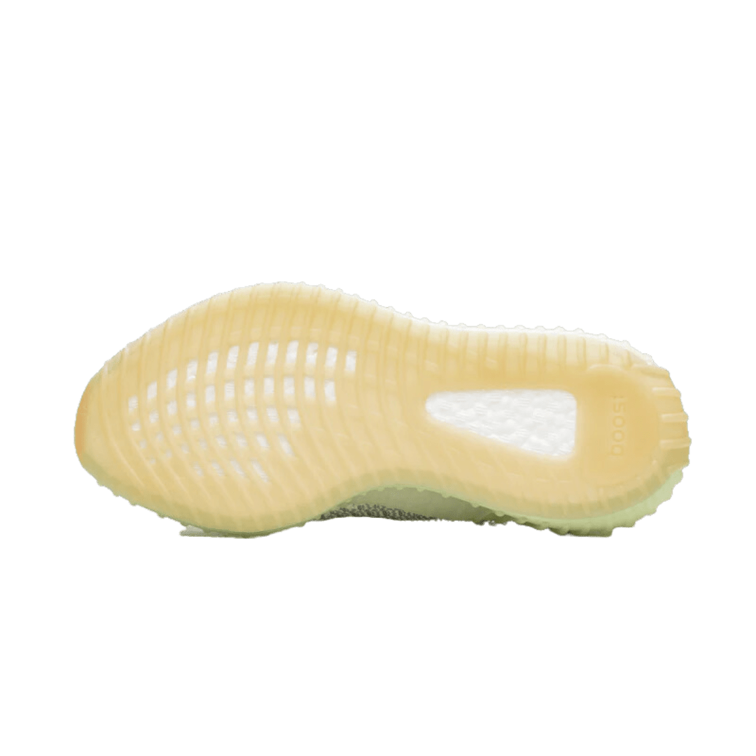 Stevige, geribbelde Adidas Yeezy Boost 350 V2 Yeshaya (niet reflecterend) sneaker op groene achtergrond