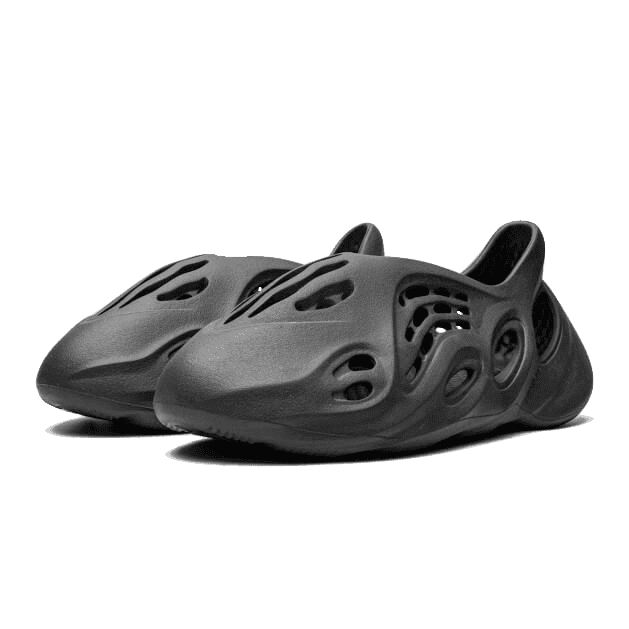 Grijze Adidas Yeezy Foam RNR Onyx sneakers op groene achtergrond