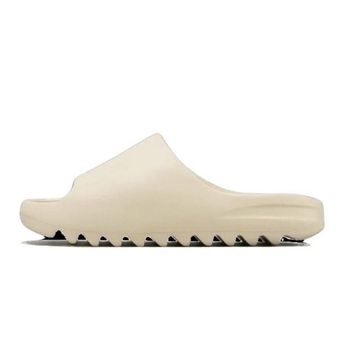 Adidas Yeezy Slide Bone - Stijlvolle en comfortabele slipper van het populaire Adidas Yeezy merk, met een effen beige kleur en een robuuste, geribbelde zool.