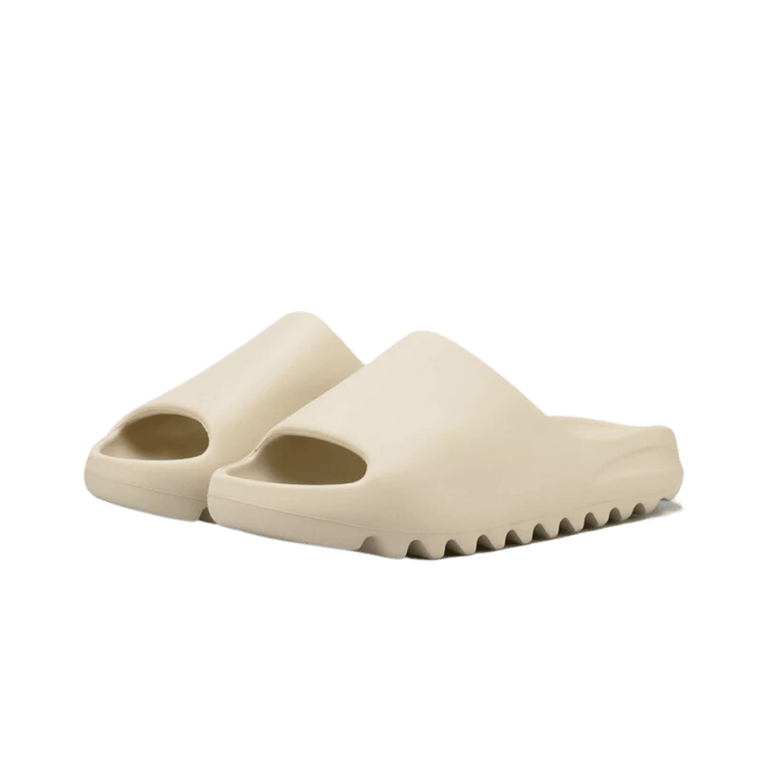 Comfortabele Adidas Yeezy Slide Bone slippers op effen groene achtergrond