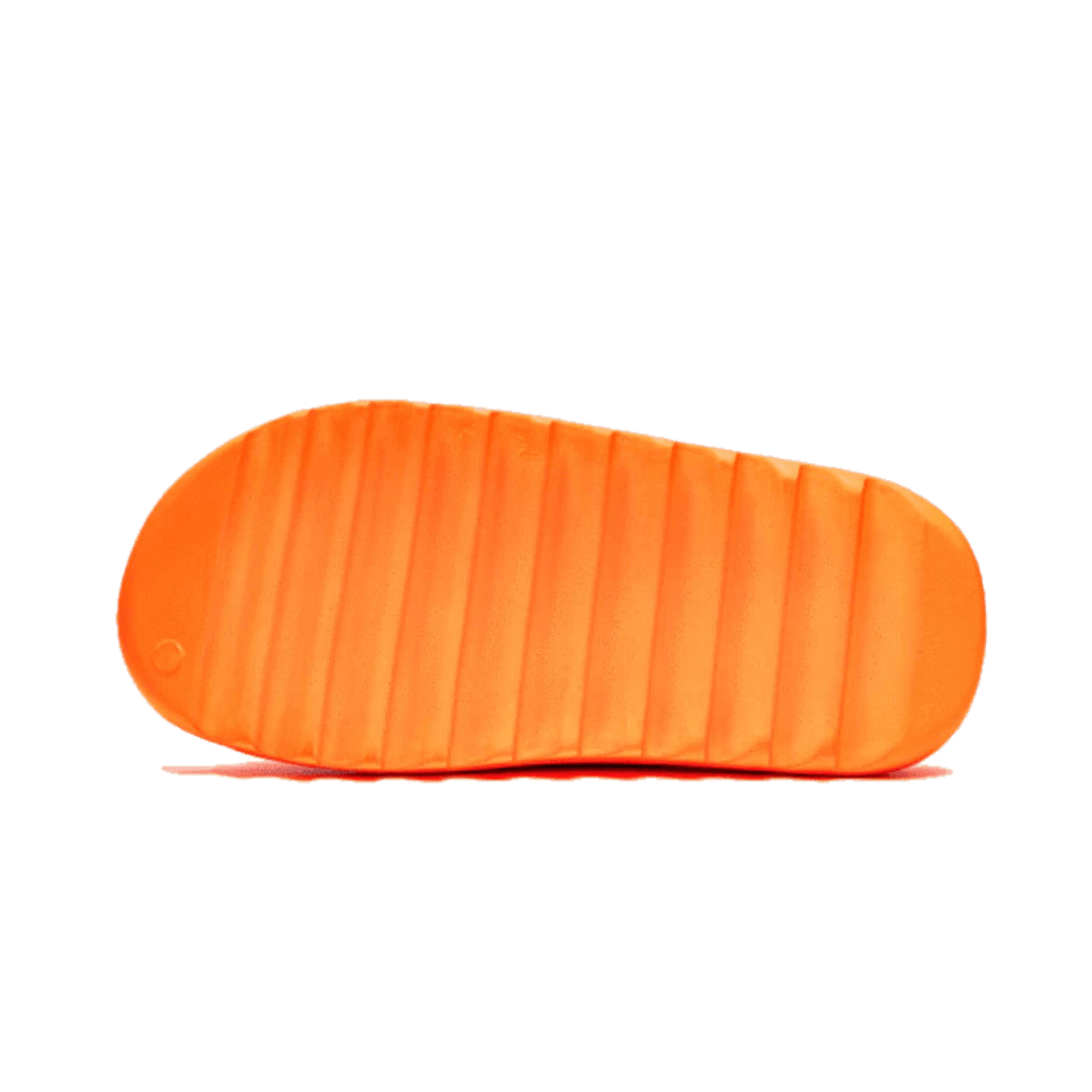 Oranje Adidas Yeezy Slide Enflame sneakers op een groene achtergrond
