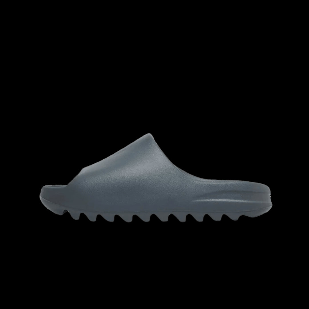 Grijze Adidas Yeezy Slide sandaal op groene achtergrond