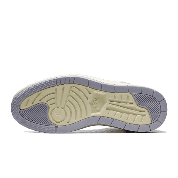 Grijze en beige Nike Air Jordan 1 High Elevate Titanium sneakers op een groene achtergrond