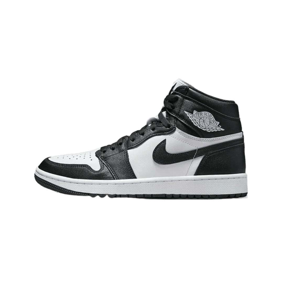 Zwarte en witte Nike Air Jordan 1 High Golf Panda sneakers op een groen oppervlak