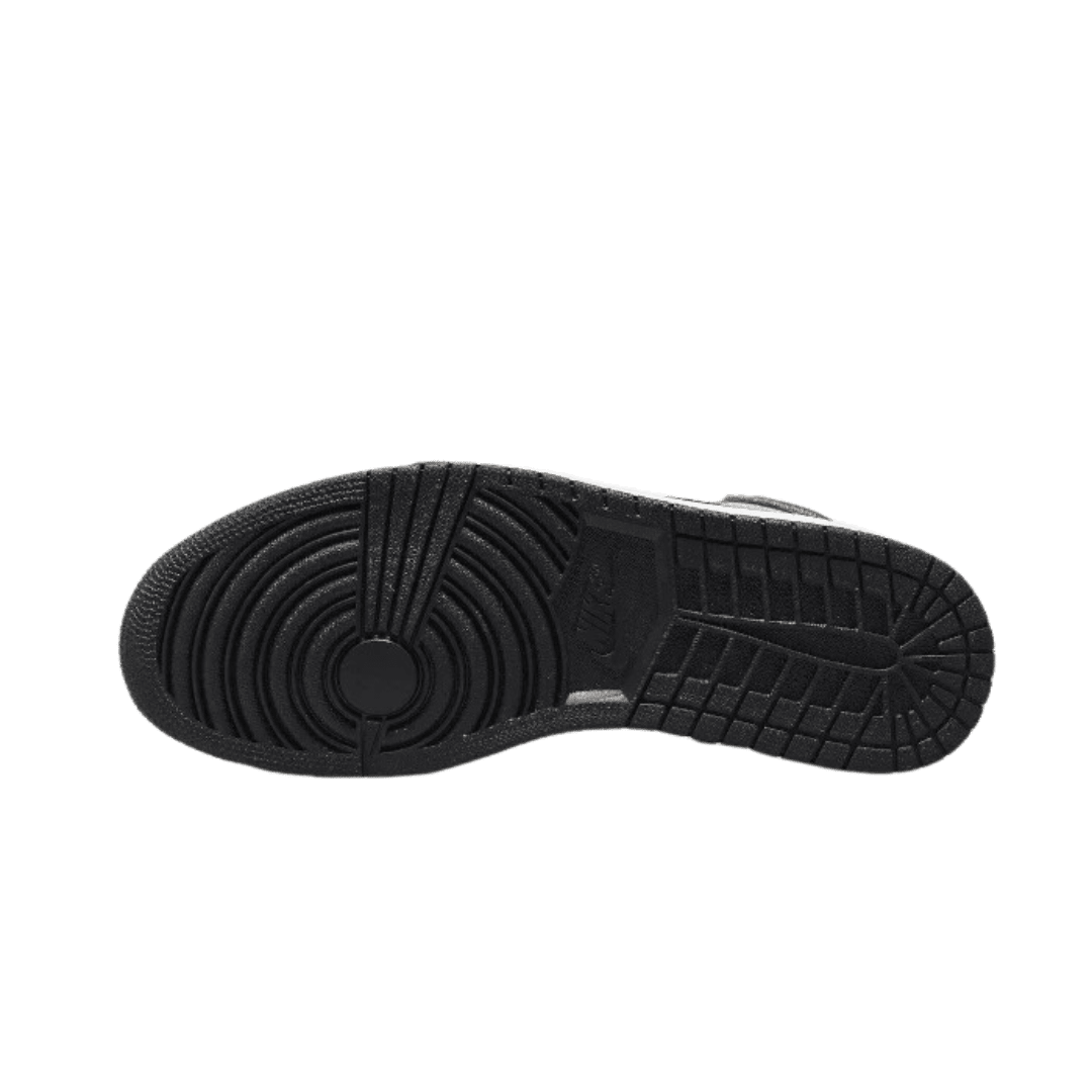 Zwarte handgemaakte Air Jordan 1 High OG sneakers met duurzame rubberen zool op een groene achtergrond.