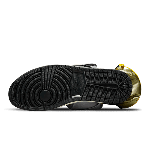 Gouden en zwarte Air Jordan 1 High OG Stash Metallic sneakers met gedetailleerd streeppatroon op de zool op een groene achtergrond.