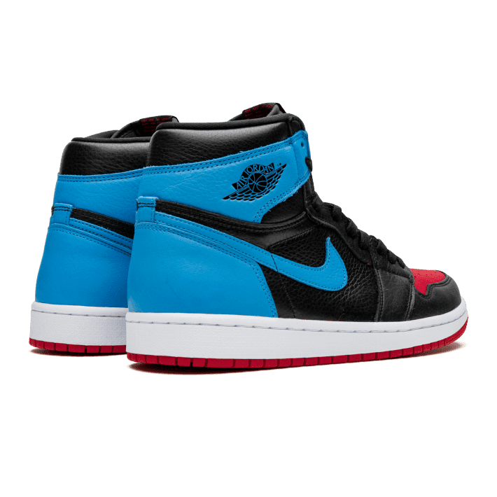 Blauwe en zwarte Nike Air Jordan 1 High OG UNC To Chicago sneakers op een groene achtergrond