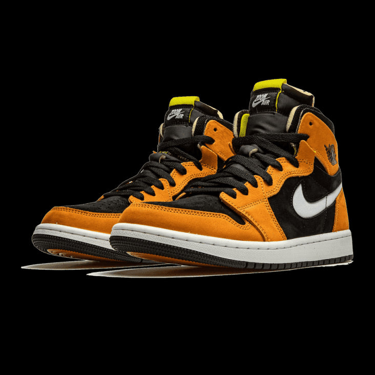 Oranje en zwarte Air Jordan 1 High Zoom Air CMFT sneakers tegen een groene achtergrond