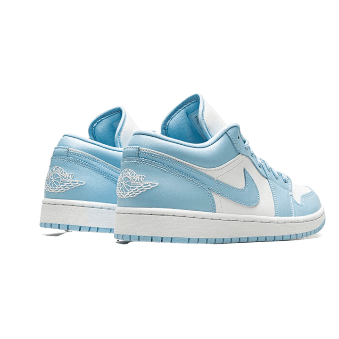 Lichtblauwe Nike Air Jordan 1 Low Aluminium sneakers op een groene achtergrond