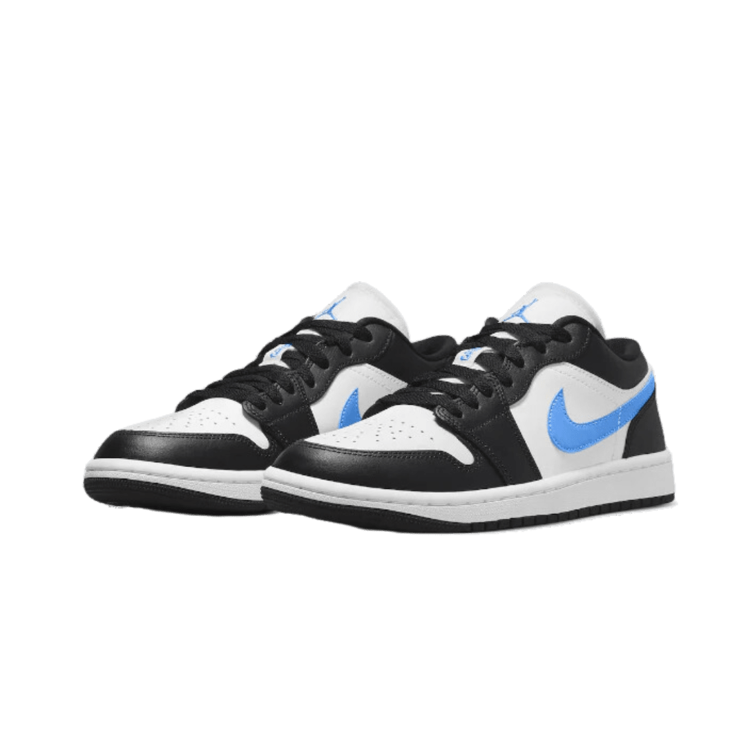 Zwarte, witte en blauwe Nike Air Jordan 1 Low sneakers op een groene achtergrond