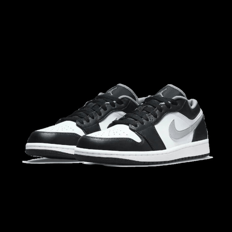 Elegante Nike Air Jordan 1 Low Black White Particle Grey sneakers op een groene achtergrond