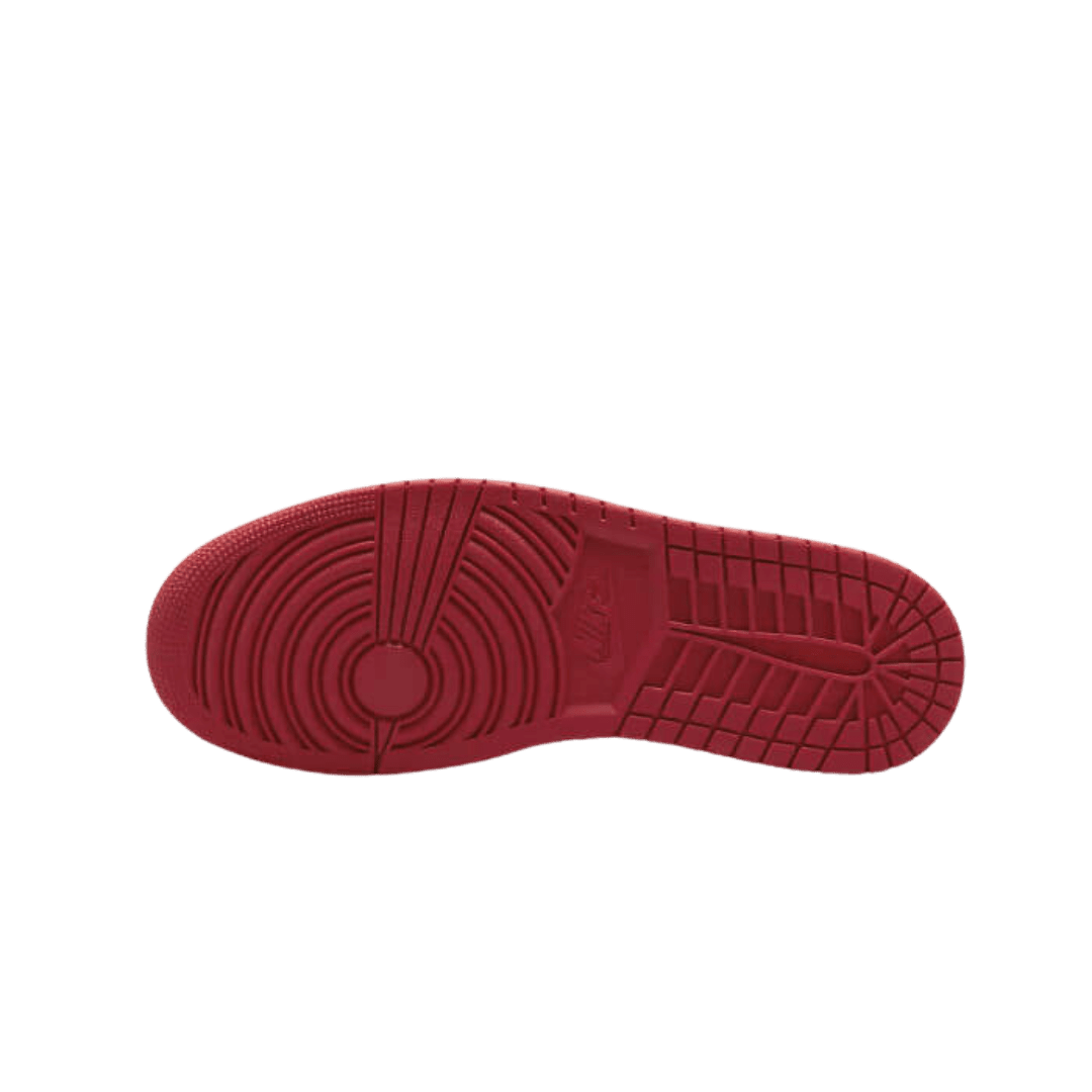 Rode rubberen zool van Nike Air Jordan 1 Low Bulls sneakers op groene achtergrond