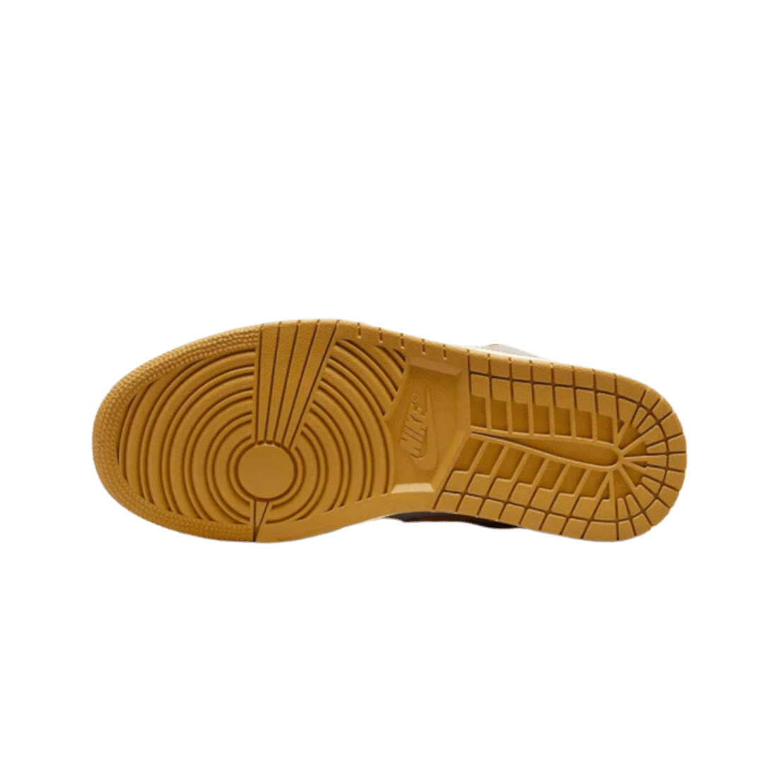 Grijs-oranje Air Jordan 1 Low Cement sneaker met een dikke, geribbelde zool op een groene achtergrond