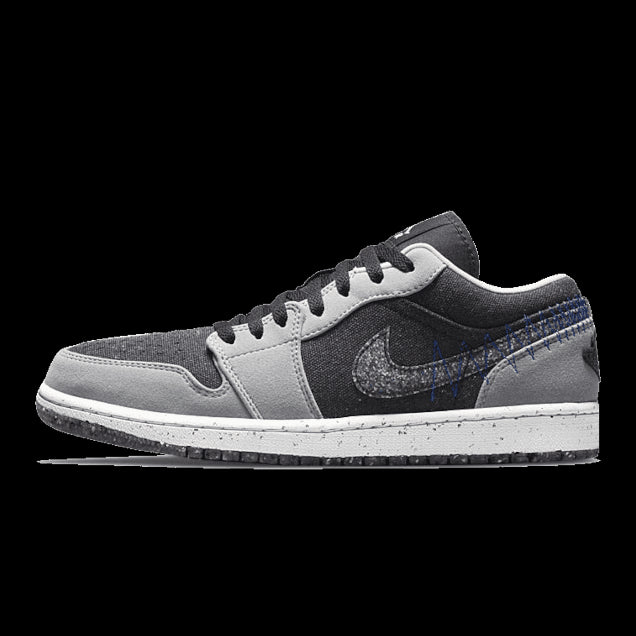 Grijze Nike Air Jordan 1 Low Crater-sneakers met contrasterende details op een groene achtergrond.