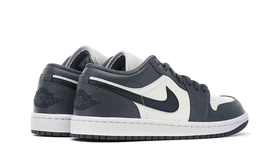 Minimalistische Nike Air Jordan 1 Low-sneakers in een donkergrijze kleur met contrasterende witte elementen. Deze sportieve schoenen met klassiek Jordan-ontwerp brengen stijl en comfort samen voor een stedelijke look.