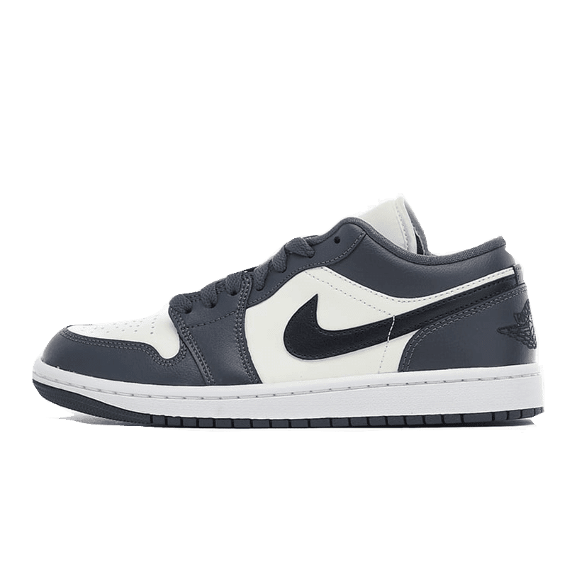 Elegant grijze en witte Nike Air Jordan 1 Low-sneakers op een groene achtergrond. De schoenen hebben een klassiek, tijdloos ontwerp met het bekende Nike-swooshlogo en bieden een comfortabele pasvorm.