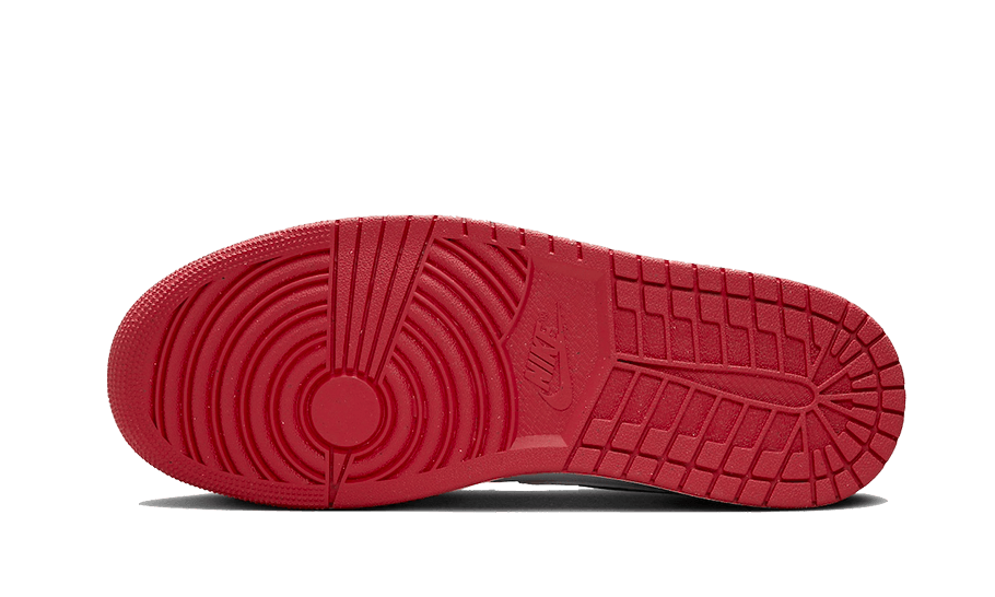 Rode Air Jordan 1 Low Dune sneakers met opvallende details en een sierlijk profiel op de groene achtergrond