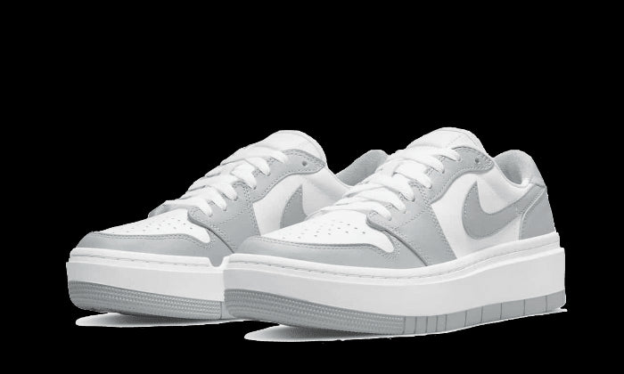Klassieke Nike Air Jordan 1 Low Elevate sneakers in wit en grijs op groen achtergrond