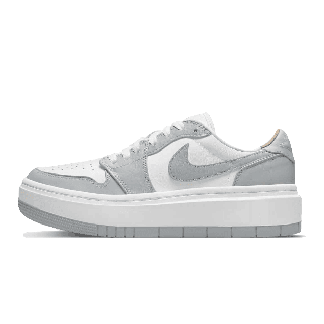 Witte en grijze Nike Air Jordan 1 Low Elevate sneakers geplaatst op een groene achtergrond