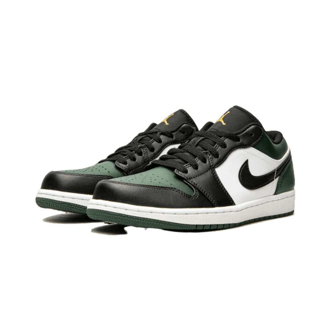 Zwart-groene Nike Air Jordan 1 Low sneakers op een groene achtergrond