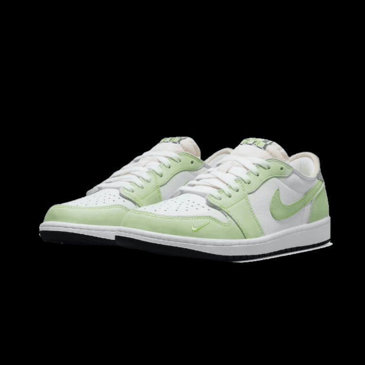 Witte Nike Air Jordan 1 Low OG Ghost Green sneakers tegen een groene achtergrond. Deze veelzijdige sneakers zijn gemaakt van licht suède en gaas materiaal, met contrasterende groene accenten. De klassieke Jordan 1-silhouet met het kenmerkende Nike swoosh-logo zorgen voor een premium en stijlvol uiterlijk.