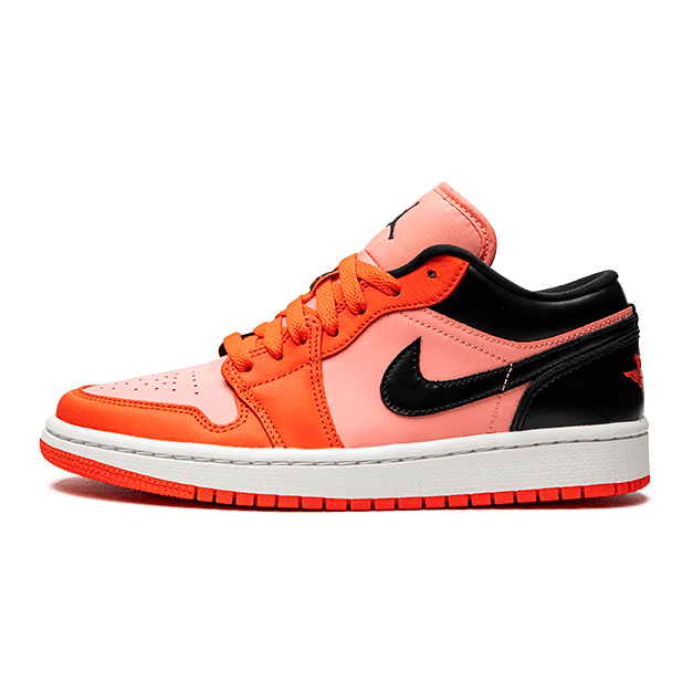 Oranje en zwarte Nike Air Jordan 1 Low sneakers tegen een groene achtergrond