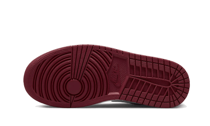 Luxe Nike Air Jordan 1 Low Pomegranate sneakers met een opvallend gestreept en gedraaid dessinu op de zool, geschikt voor een stedelijke stijl.