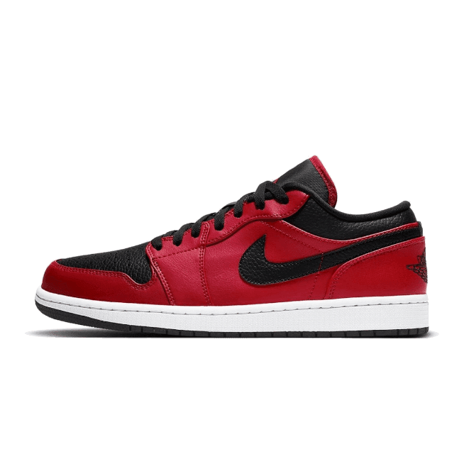 Rode en zwarte Air Jordan 1 Low Reverse Bred Pebbled Swoosh sneakers op groene achtergrond