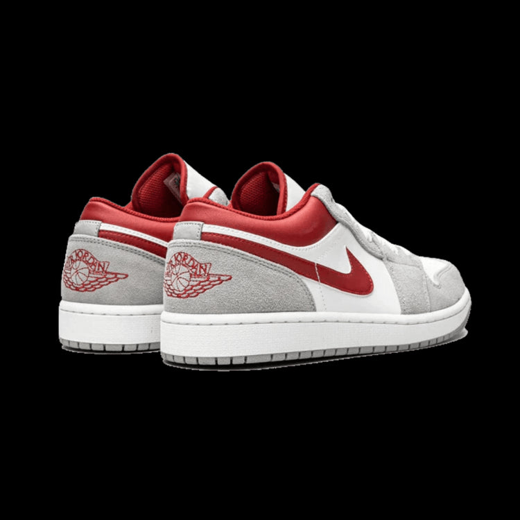 Rode en grijze Air Jordan 1 Low SE sneakers op een groene achtergrond
