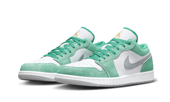 Minimalistische Nike Air Jordan 1 Low SE-sneakers in een saliegroen en grijs kleurenschema, geplaatst op een groene achtergrond.