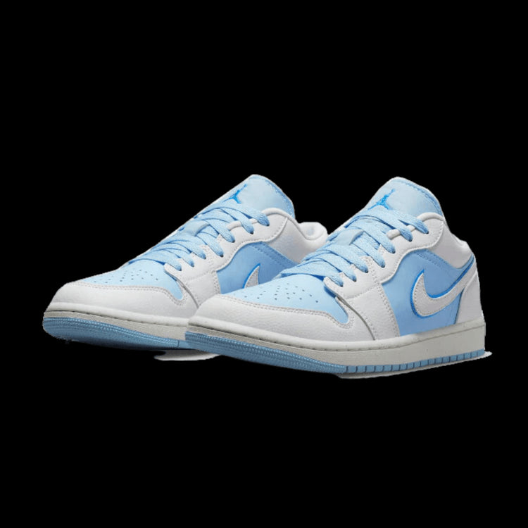 Klassieke Nike Air Jordan 1 Low SE Reverse Ice Blue sneakers in lichte tinten blauw en grijs, geplaatst op een groene achtergrond.