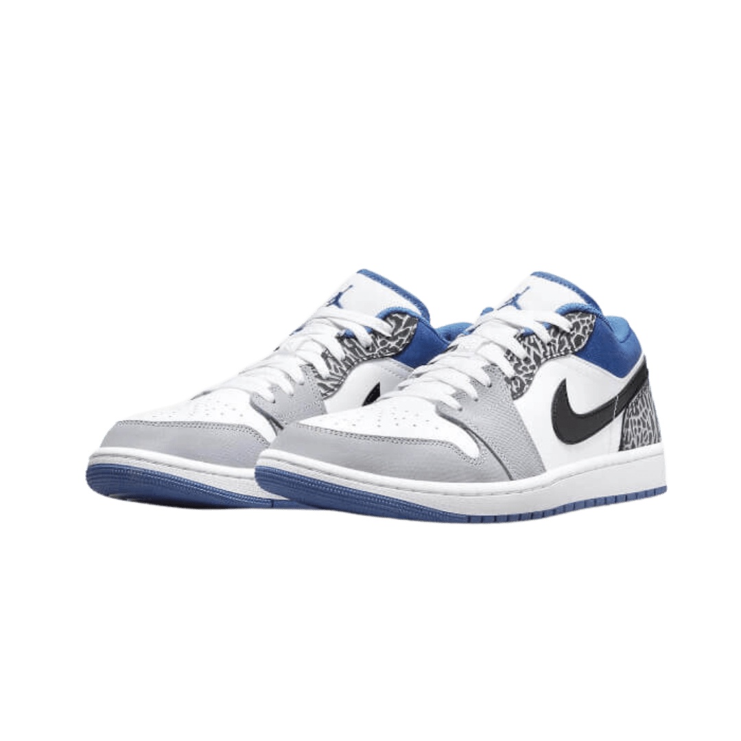 Elegante Air Jordan 1 Low SE True Blue sneakers van Nike op een groene achtergrond