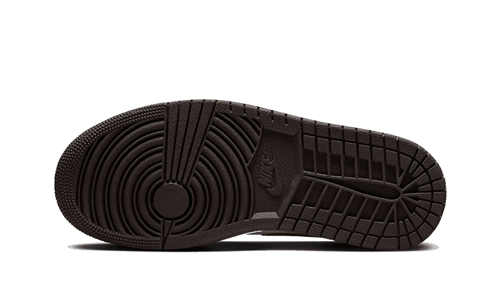 Getextureerde rubberen zool van de Nike Air Jordan 1 Low Shadow Brown sneakers, tegen een groene achtergrond geplaatst.