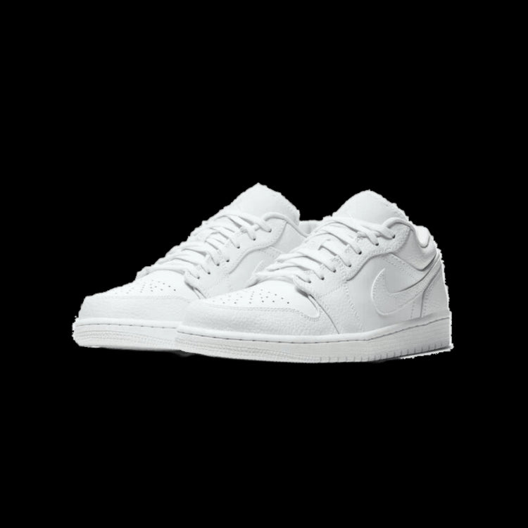 Glanzende witte Nike Air Jordan 1 Low sneakers tegen een groene achtergrond
