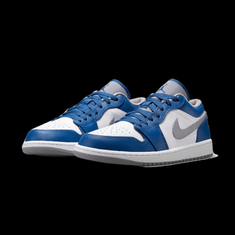 Blauwe en witte Nike Air Jordan 1 Low True Blue sneakers op een groene achtergrond
