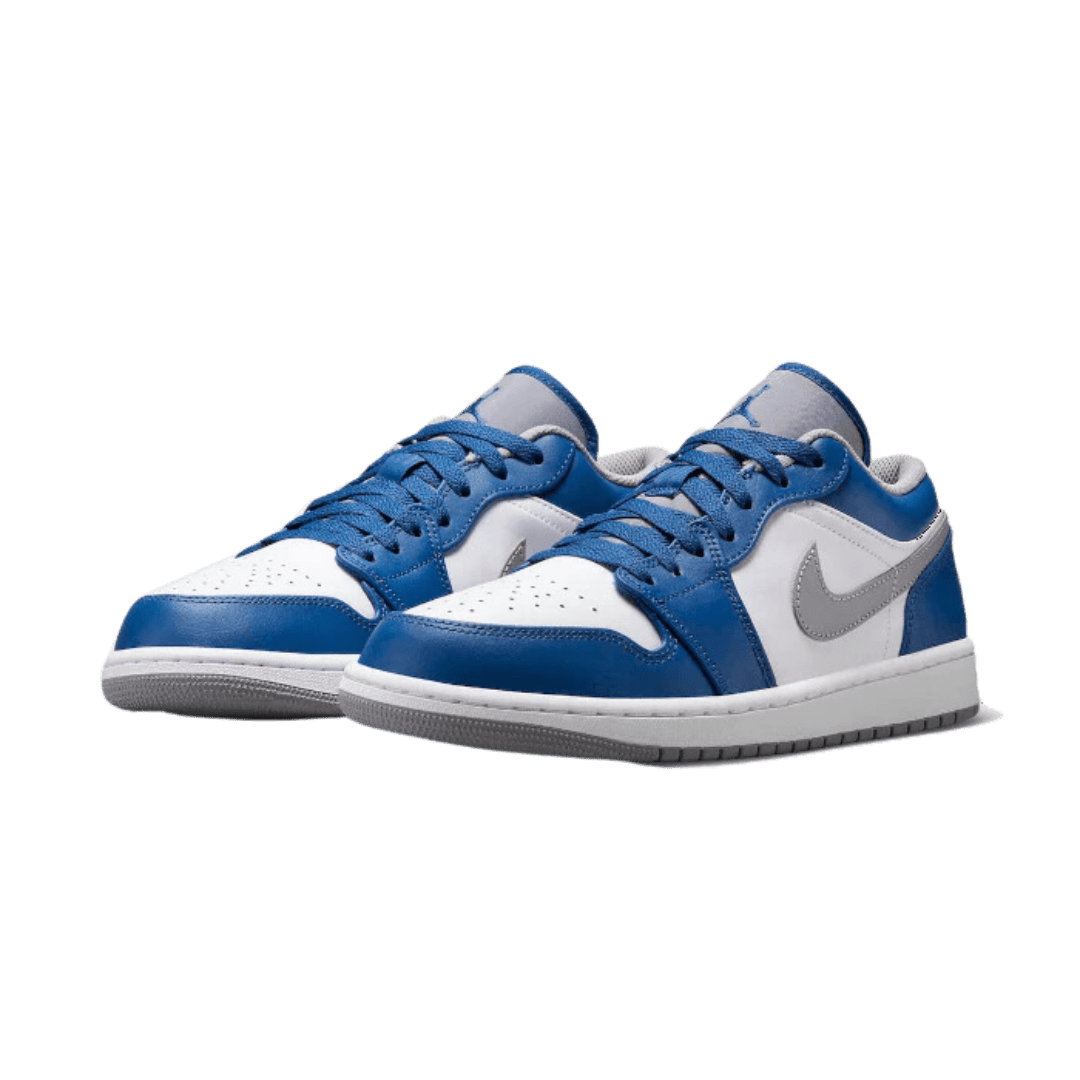 Blauwe en witte Nike Air Jordan 1 Low True Blue sneakers op een groene achtergrond