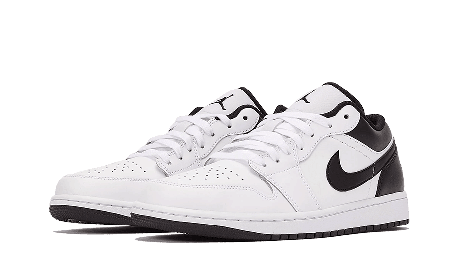 Witte en zwarte Nike Air Jordan 1 Low sneakers gecentreerd in het beeld op een groene achtergrond. De klassieke Jordan-look met een laag en licht ontwerp voor veelzijdig gebruik.