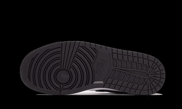 Exclusieve Nike Air Jordan 1 Low sneakers in wit en zwart op een groene achtergrond.