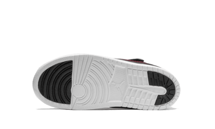 Witte kinder Air Jordan 1 Low sneakers met contrasterende rode zijpanelen. De klassieke basketbalstijl en duurzame constructie maken deze schoen tot een populaire keuze voor de jeugd.