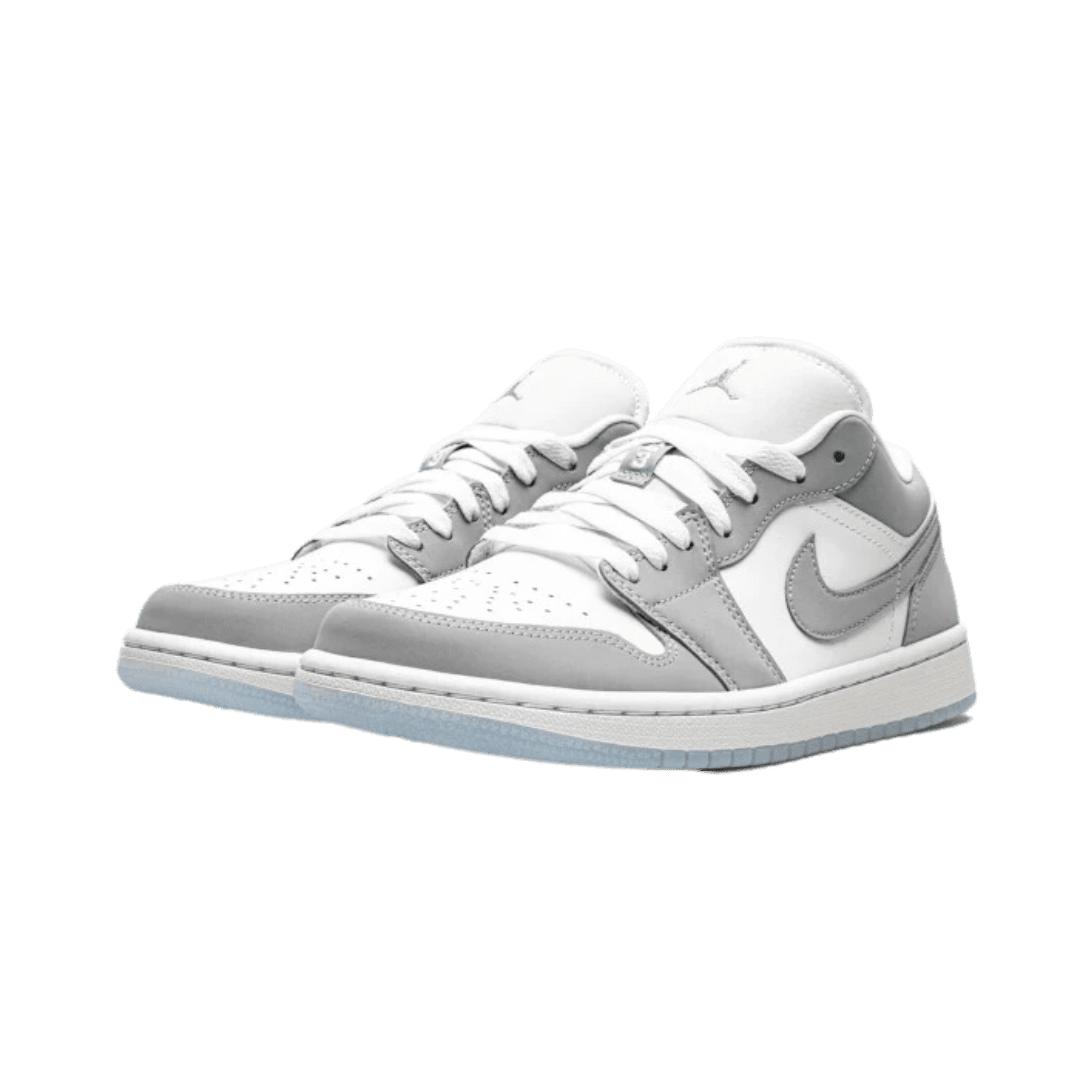 Elegante Nike Air Jordan 1 Low Wolf Grey sneakers op een groene ondergrond