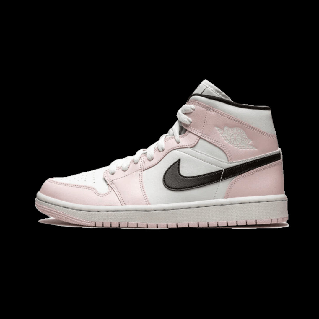 Roze en witte Air Jordan 1 Mid Barely Rose sneakers op een groene achtergrond