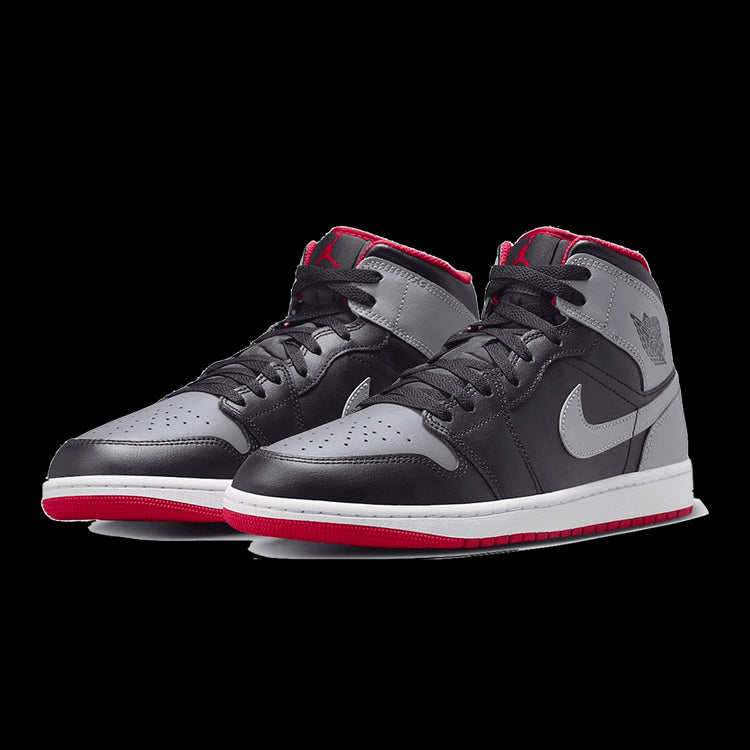 Stijlvolle Nike Air Jordan 1 Mid sneakers met zwart, grijs en rood ontwerp op groene achtergrond