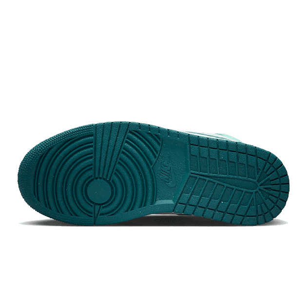 Turquoise Nike Air Jordan 1 Mid sneakers met een uniek gestructureerd zoolontwerp op een groene achtergrond